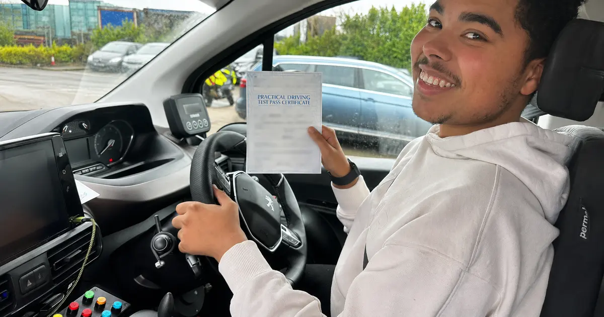 MPL learner celebrating a driving-test pass in a car fitted with full hand controls